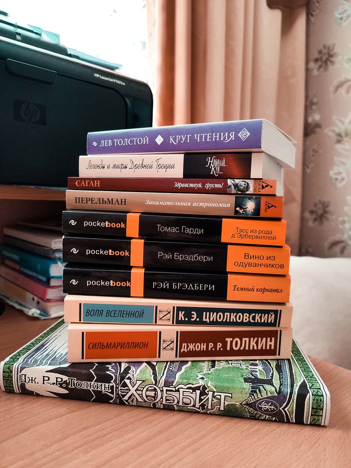 about-us-02 A stack of various books in different languages on a wooden table, ideal for education themes.